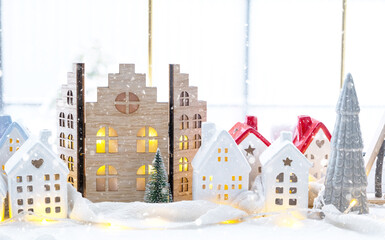 Cozy Christmas decor tiny house of small size on window sill with snow outside the window. Gift for New Year. Insurance, moving to new house, mortgage, rent and purchase real estate