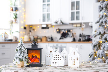 Cozy Christmas decor tiny house of small size on table of festive white modern kitchen. Gift for New Year. Insurance, moving to new house, mortgage, rent and purchase real estate