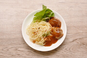 spaghetti dressing fried meatball stuffed cheese in ketchup sauce and cos lettuce on plate 