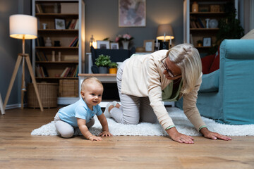 Grandmother taking care of her grandchild while his parents working. Senior woman work as a nanny,...