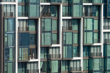Window residential building apartment. Modern city skyscraper in day light. Apartment windows in modern skylines with day light. Many block of estate. Real estate. Closeup. Side view. Ornamented.
