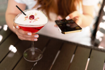 Woman with mobile phone and cocktail glass with berries beverage. Good afternoon. Wellness and...