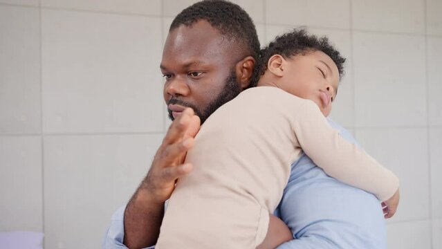 Loving African American dad embracing baby and baby girl sleeping on stepfather shoulder. Happy family with pleasure spending time at home, Being a father and Fatherhood family love relationship