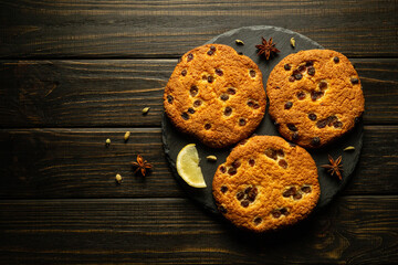 Oatmeal raisin cookies on a serving board prepared for breakfast tea. Dark background for advertising