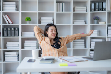 Young Asian woman employee relaxing after working in the office.