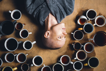 Bald woman and many cups of coffee. Cheerfulness, deadline, addiction to coffee concept.