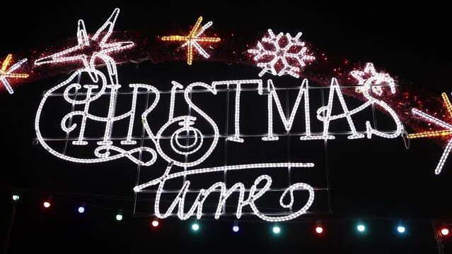 LED light that says 'Christmas Time' in churches at night. Concept of Christmas, celebration, darkness, LED, neon and Christmas lights.
