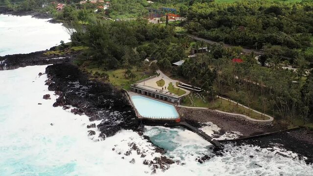 Aerial drone view of Puits des Anglais with an empty pool, natural pool and high breaking waves, Saint-Philippe, Reunion.