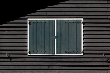 Black wooden wall with white frame and green window, Abstract geometric pattern with light and shadow, Classic horizontal line wall, Can be used as background for display.