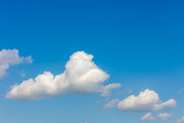Beautiful white fluffy cloud floating in blue sky in sunny day, Cumulus are clouds which have flat bases and are often described as puffy, Horizon nature background with free copy space.
