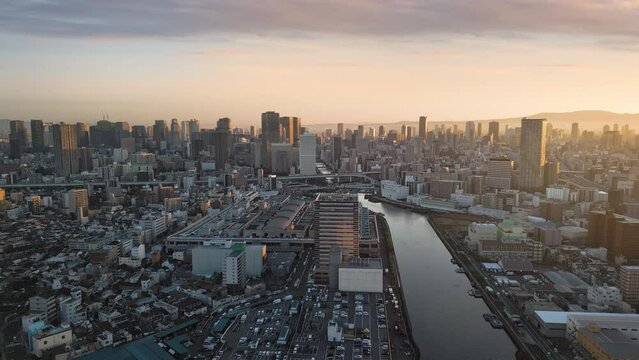 osaka business city aerial view drone at sunrise flying to umeda financial and transportation district hub,modern building and skyscrapers in the background at dawn