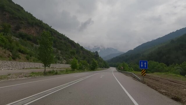 highway road in the countryside, roadside and asphalt, green trees and mountains 