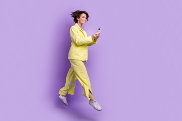 Fototapeta na wymiar Full body photo of wearing stylish lime color suit young woman bob brown hair blogger browsing iphone isolated on violet background