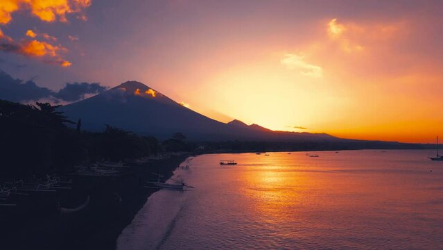 Amazing Sunset at Amed on the Jemeluk Beach with views of volcano Gunung Agung. Aerial Drone view 4K.