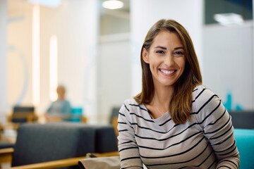 Happy woman in waiting room at medical clinic looking at camera.