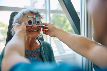 Happy senior woman checking her vision at ophthalmological clinic.