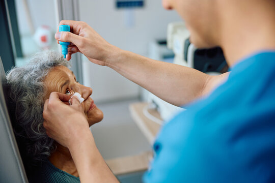 Senior woman having pupil dilation during eyesight exam at ophthalmologist.