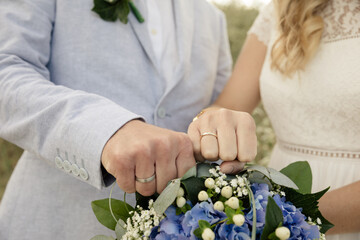 Braut und Bräutigam präsentieren Eheringe und ihr Hochzeitsoutfit - 689680539