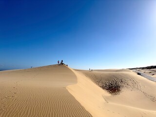 Fototapeta na wymiar Blick auf eine Touristengruppe auf der hohen Sanddünenlandschaft bei Valdevaqueros mit Blick auf den Atlantik, Tarifa, Cádiz, Andalusien, Spanien, fantastische Landschaft, Tourismus, Reisen