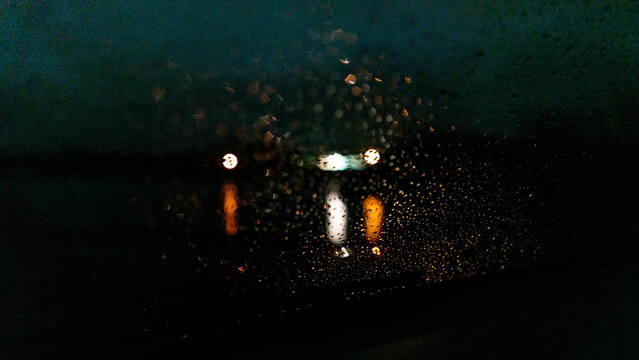 Rain on the window with distant lights at night 