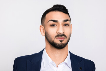 Portrait of serious concentrated in bad mood man looking at camera. Handsome buisnessman successful guy with beard standing over grey background in studio isolated.