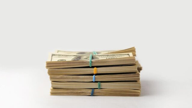 Dollars money stack, cash income, cash profit concept. Stacks of dollar money appear and fold into large stack on white background. Close-up