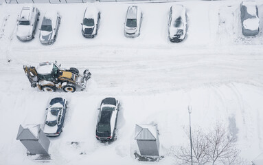 Tractor cleaning city street, removing snow and ice