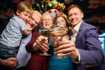 People holding glasses with champagne celebrating New Year in restaurant