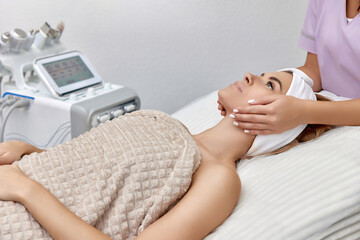 Beautiful woman receiving facial massage in beauty salon. Skin care.