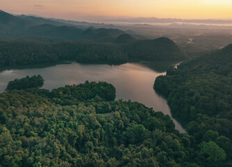 Beautiful landscape of green mountains and lake in the morning with sunrise sky. Nature landscape. Watershed forest. Water and forest sustainability concept. Aerial view of mountain with green trees.