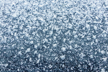 Big fluffy snowflakes on the surface of the ice. Winter and Christmas background