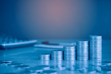 Up stack money coin with calculator in the background. Business and Financial concept with blue...