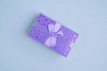 luxury gift box with a purple bow on a blue background. View from above. A gift for him on Father's Day or Valentine's Day. Corporate gift or birthday party concept. place for logo. copy space. banner