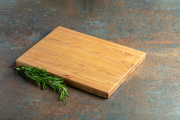 Cutting board and rosemary on a rusty iron table.