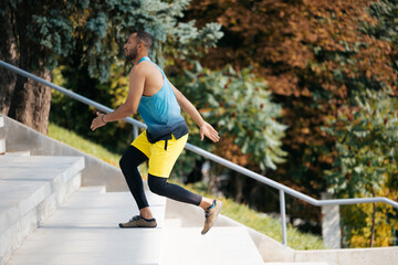 Dark-skinned athlete exercising on the stairs