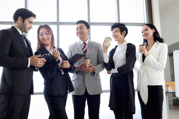 Five happy businesspeople, group of businessmen and businesswomen talking and drinking coffee during taking a break. Happy worker staff team at office workplace. People working together.