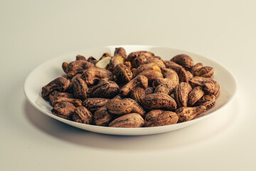 Close up of roasted cashew nuts with skin on white background