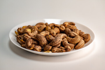 Close up of roasted cashew nuts with skin on white background