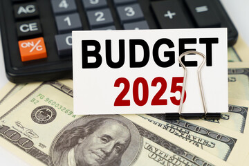 On the dollars there is a calculator and a business card with the inscription - BUDGET 2025