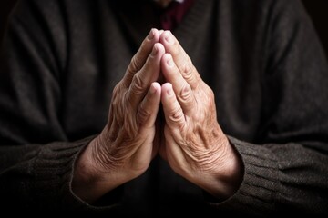 the hands of a man folded in prayer