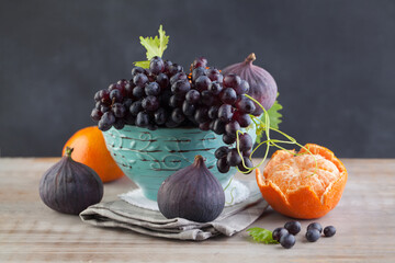 Variety fruit orange tangerine, figs and grape  with green leaves, healthy food background