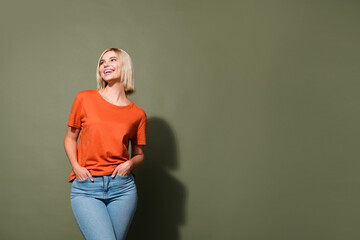 Photo portrait of lovely young lady hands pockets look up empty space wear trendy orange garment...