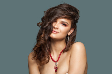 Beautiful stylish brunette woman jewelry model with long curly hair, healthy skin and earring and...