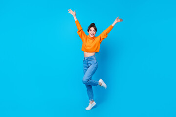 Full length photo of impressed funky lady wear knitted pullover rising arms having fun isolated blue color background - obrazy, fototapety, plakaty