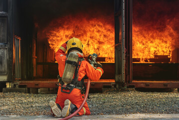 Firemen use extinguisher water fight fire burn during firefight training. Firefighter wearing fire...
