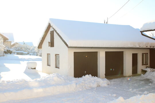 Eine Garage mit Schnee bedeckt im Sonnenlicht, Winter Wunderland Bayern