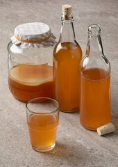 Jar, bottle and glass with homemade Kombucha drink close up