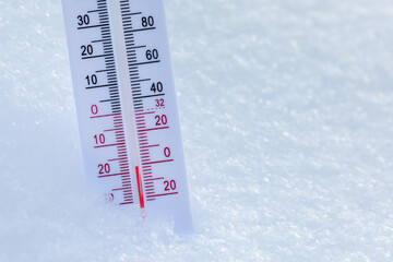 Outdoor thermometer in snow shows cold winter temperature