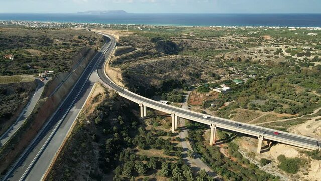 Aerial top view by drone of cretan landscape with cars on the road.