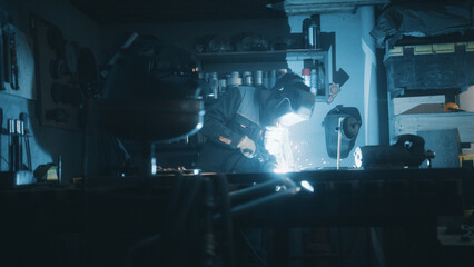 A man works with a welding machine at a factory